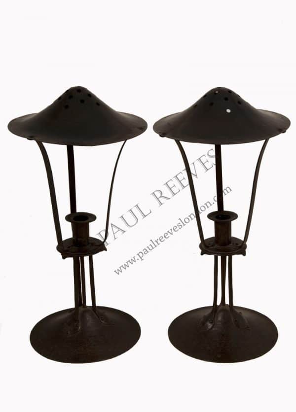 A pair of iron & copper candlesticks