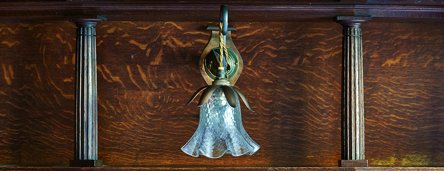 A rare and antique light displayed against a wooden panel
