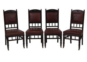 A set of four ebonised side chairs
