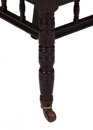 the castor wheel on an ebonised side chair